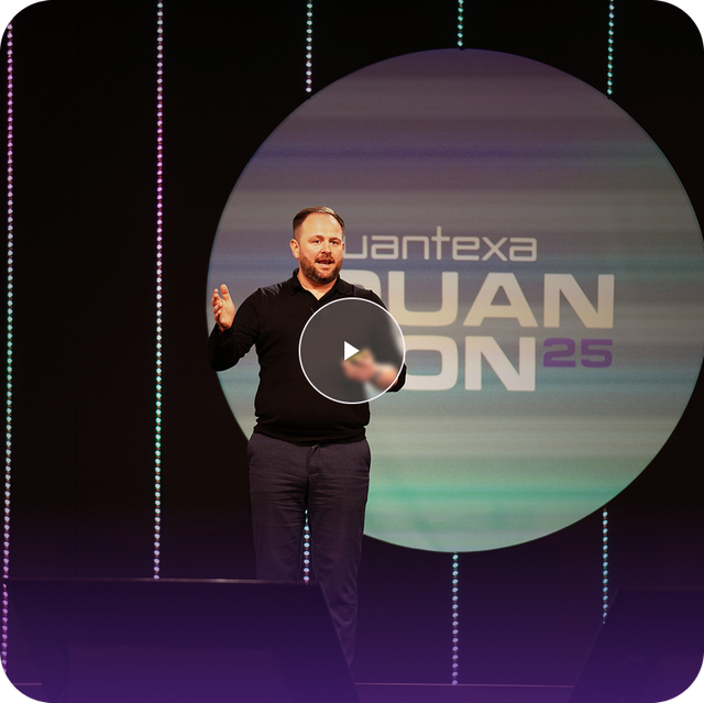 Speaker on stage with QuanCon25 logo