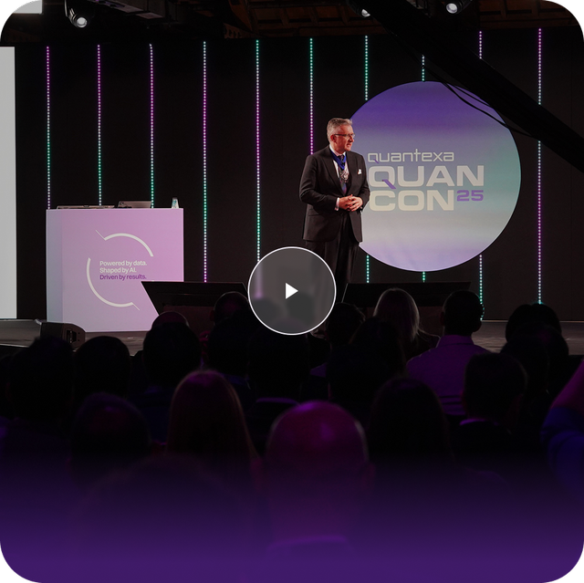 speaker on stage with QuanCon25 logo in background